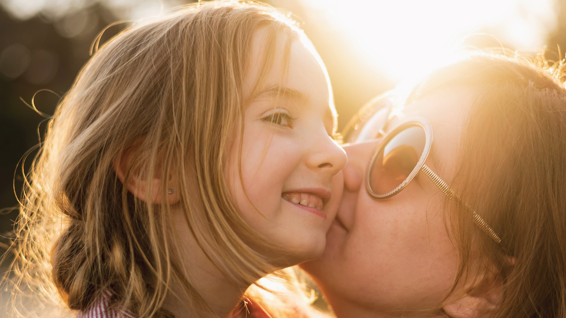 mother-kissing-daughter_1980x1080